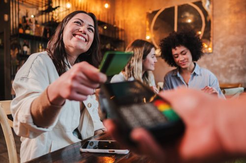 Woman spending with credit card in a restaurant