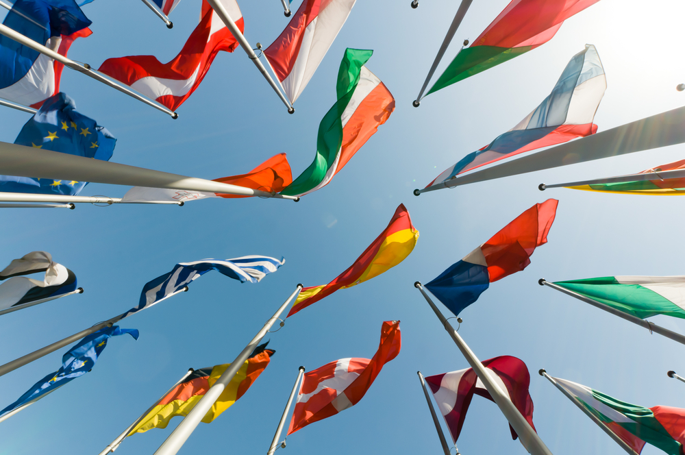 World flags view from the ground up, with blue skies.